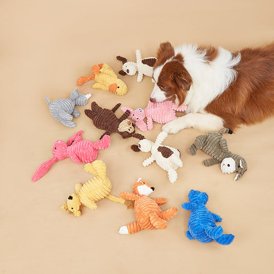 Dog playing with colorful plush toys on a beige surface