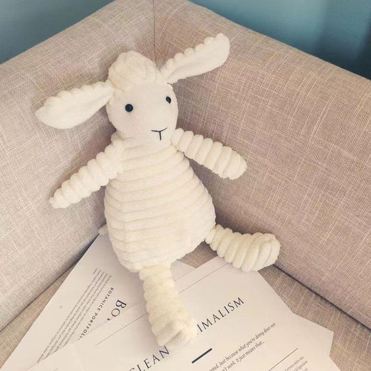 White knitted rabbit toy on a beige couch with a magazine underneath